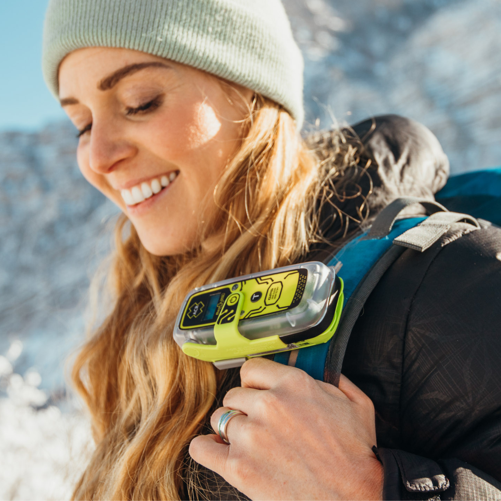 Randonneuse hivernale portant un personal locator beacon ACR ResQLink View RLS fixé à la bretelle de son sac à dos.