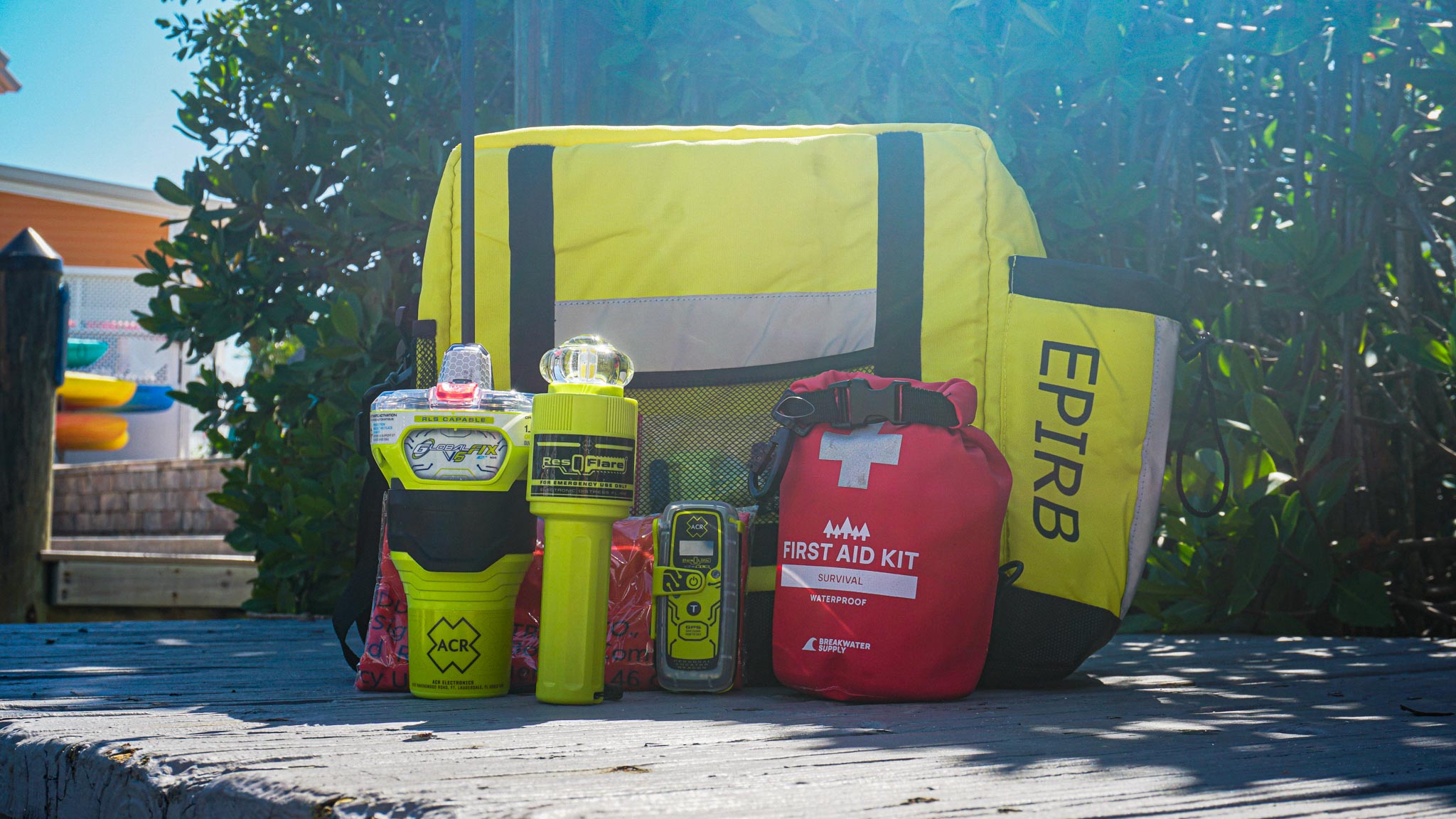ACR GlobalFix V6 EPIRB and ResQLink personal locator beacon alongside a ditch bag and marine safety equipment